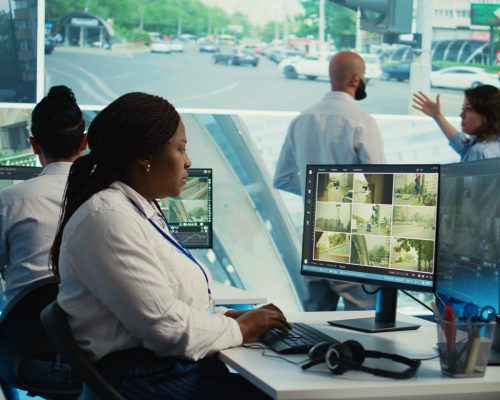 African american employee gathers data on cars in traffic through red light radar CCTV system, using real time surveillance footage for government safety activity. Camera B.
