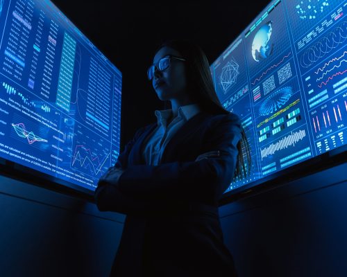 The businesswoman standing near the blue monitor